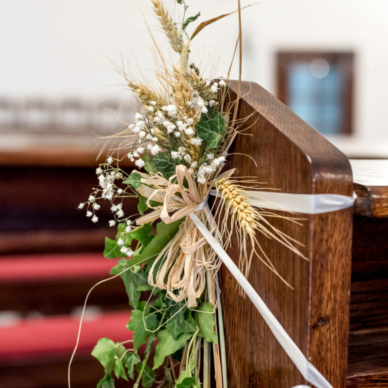 A vertical closeup shot of decorative plants on a wooden wedding chair