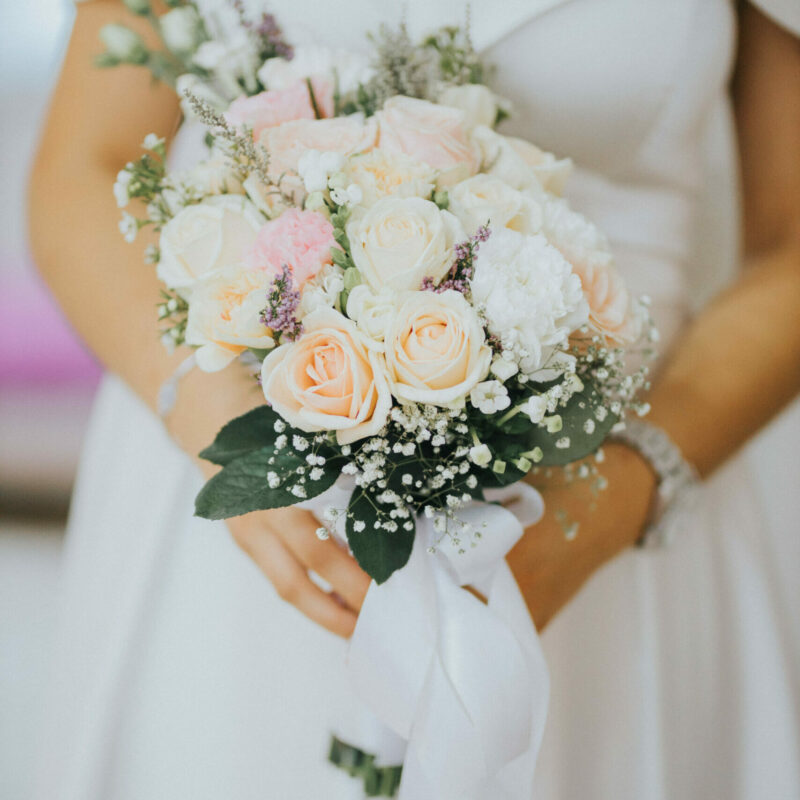 A vertical shot of a bride with a bouquet