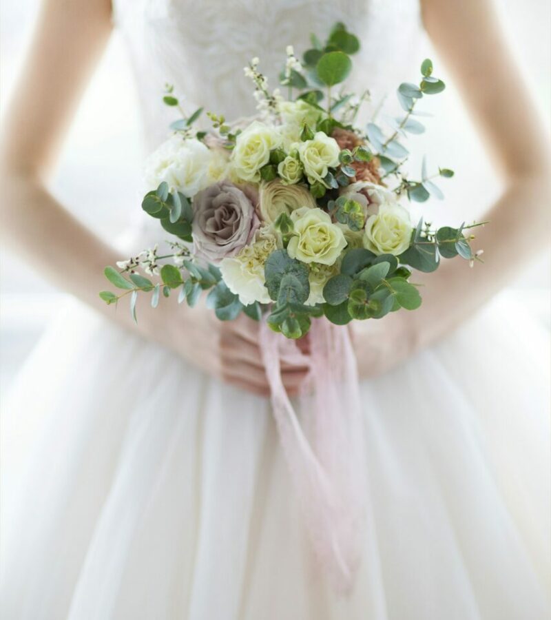 young-beautiful-woman-with-bouquet-posing-in-a-wedding-dress-close-up.jpg